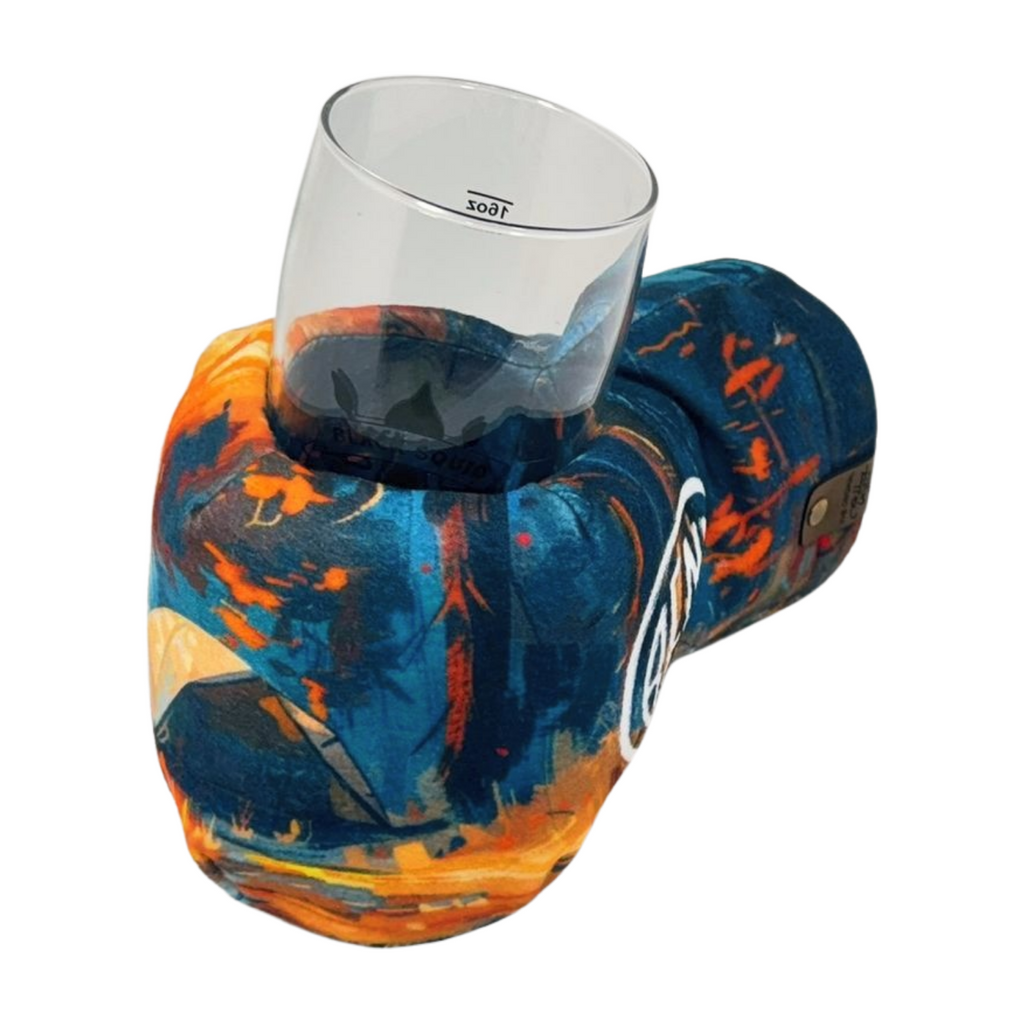 Adventure Camp Giddyup Glove™ holding a glass, insulated mitten for secure hands-free sipping during outdoor activities.